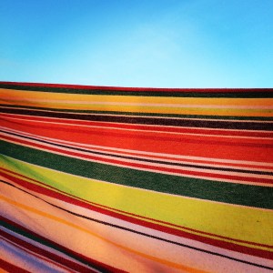 The edge of a hammock on the top of my friend's house boat against s summer sky. 