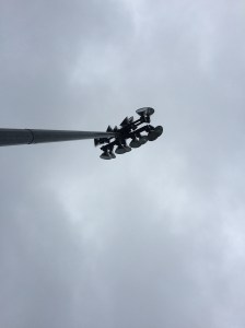 Lights at the North Delta baseball diamond under a rainy sky.